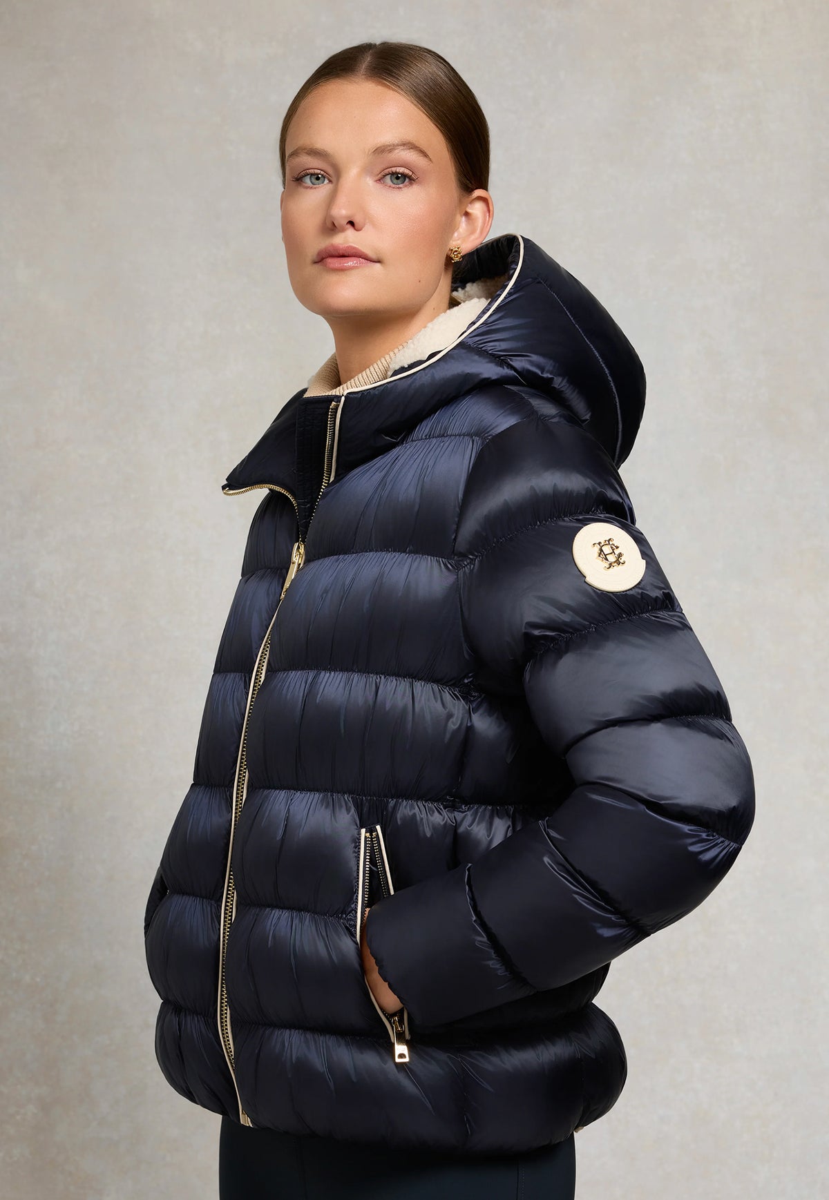 Holland Cooper Harrow Padded Jacket in Ink Navy, featuring a semi-gloss quilted outer, borg fleece lining, piped pockets and embroidered sleeve badge.
