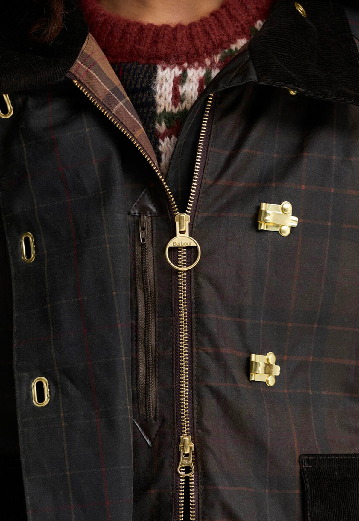 Close-up of the Barbour Hazelwood Checked Waxed Jacket featuring brass fisherman clips and patchwork check fabric.