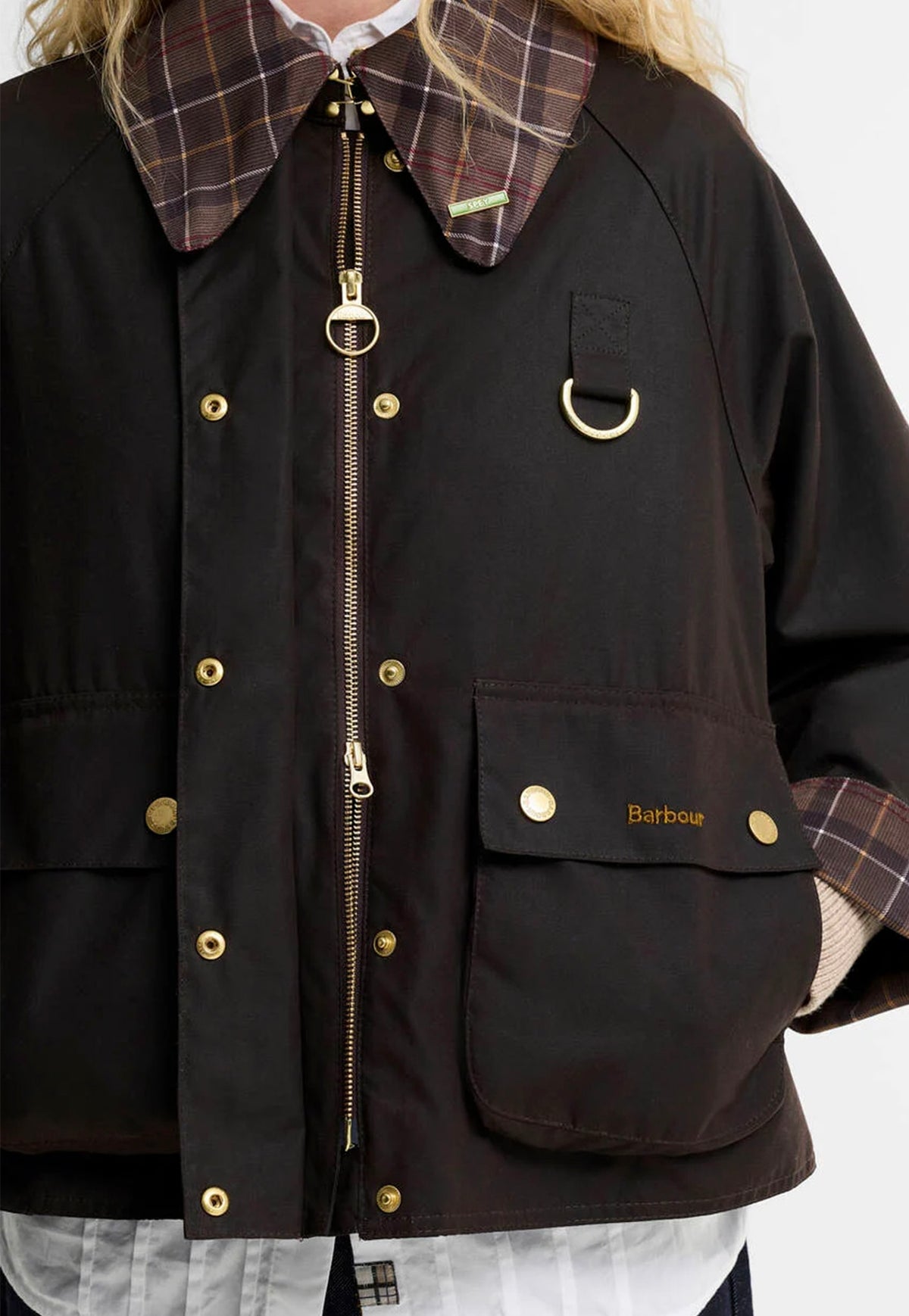 Close-up of the Barbour Icons Tartan Collar Spey Waxed Jacket featuring tartan cord detailing and brass hardware.