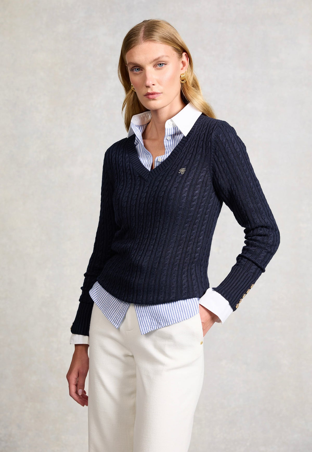 Holland Cooper Seattle V-Neck Knit in Ink Navy, featuring a cable-knit design, V-neckline, long sleeves and signature gold HC hardware at the shoulders and cuffs.